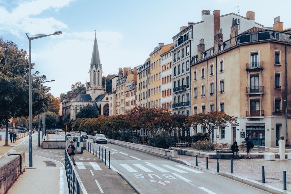Scène de rue captivante à Lyon, France, mettant en valeur l'architecture historique et la vie urbaine vibrante.