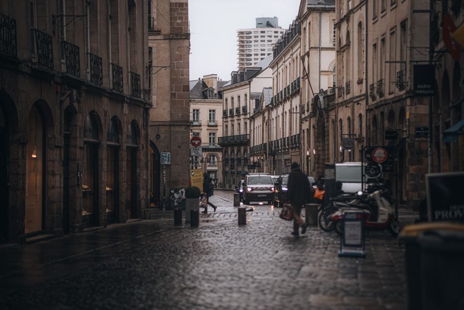 Une scène de rue européenne atmosphérique avec une architecture historique et une ambiance mélancolique avec un chemin en pavés.