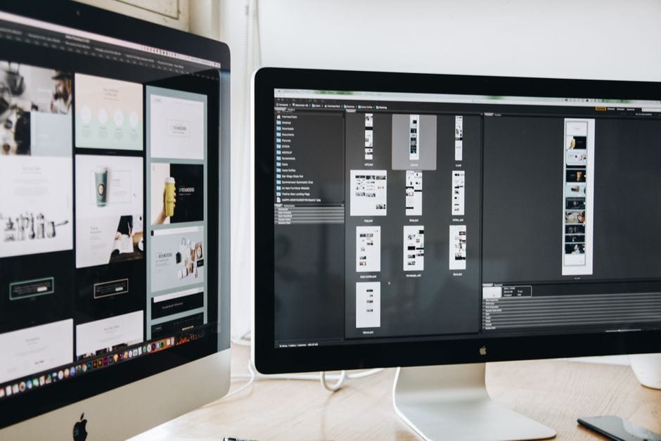 Un espace de travail moderne avec des moniteurs d'ordinateur doubles affichant des projets de conception web, mettant l'accent sur la technologie et la productivité.