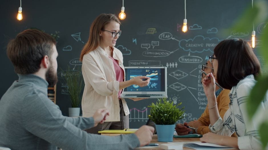 Une équipe diversifiée collaborant avec des outils numériques dans un environnement de bureau créatif.