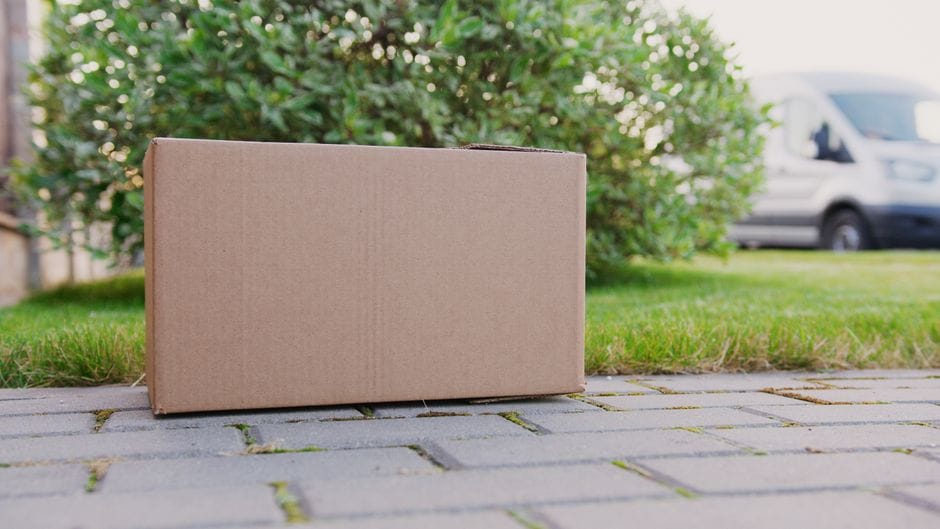 Un gros plan d'une boîte en carton sur un allée, idéale pour les thèmes de livraison.