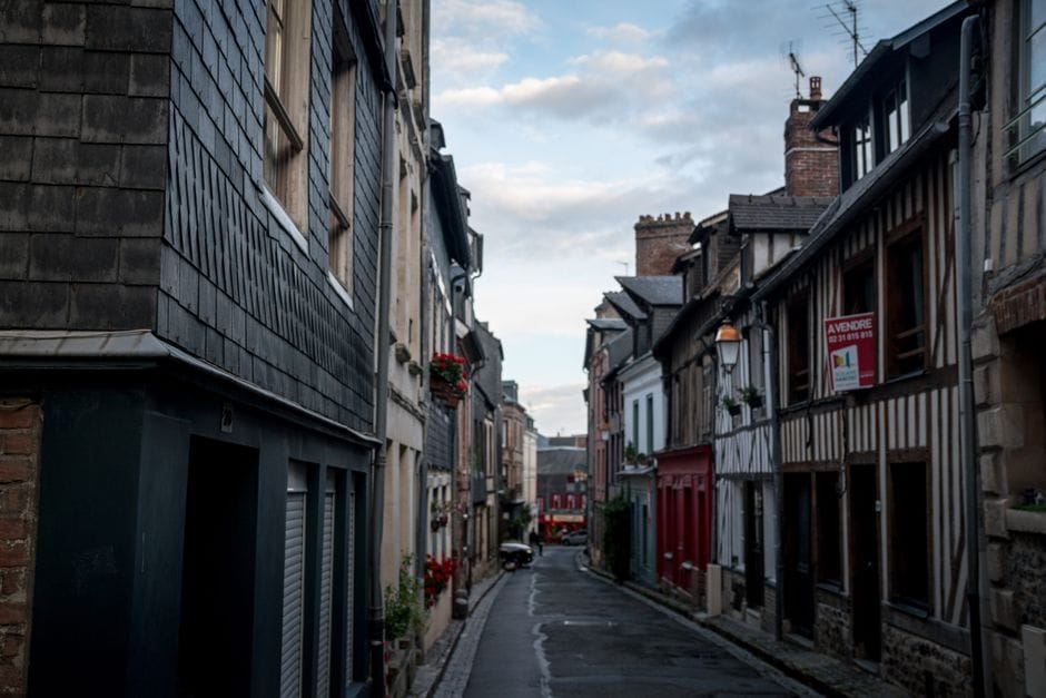 Explorez les charmantes rues pavées et l'architecture historique de Honfleur, France, dans cette vue pittoresque.