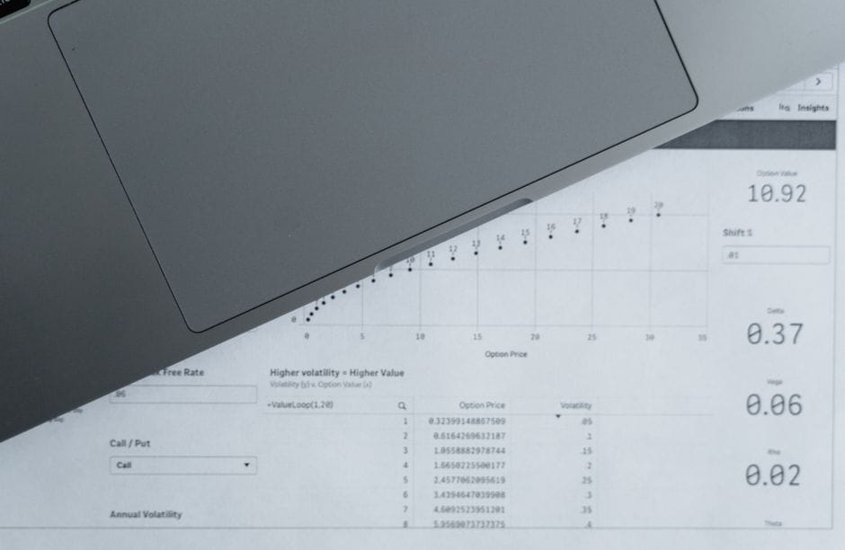 Une vue de haut des feuilles de données analytiques et d'un ordinateur portable, idéale pour des thèmes d'analyse commerciale.