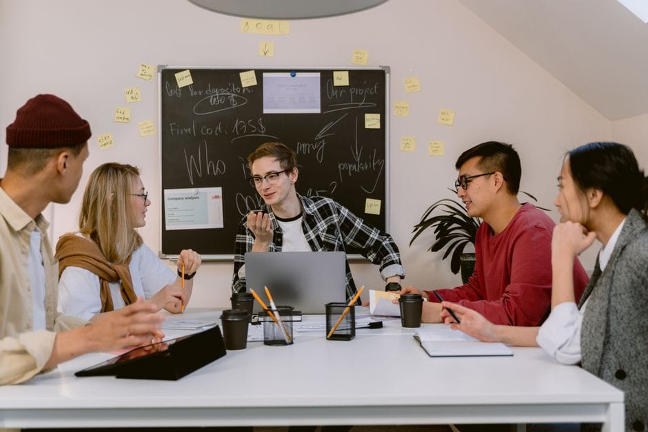 Un groupe de jeunes professionnels collaborant sur un projet dans un cadre de bureau moderne.