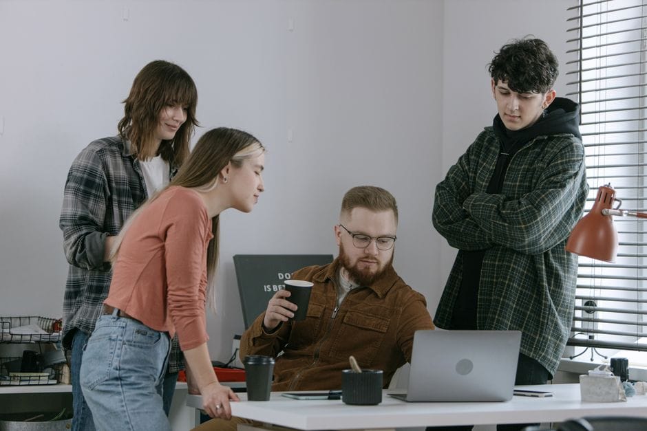 Un groupe de jeunes professionnels participant à une réunion collaborative dans un bureau moderne.