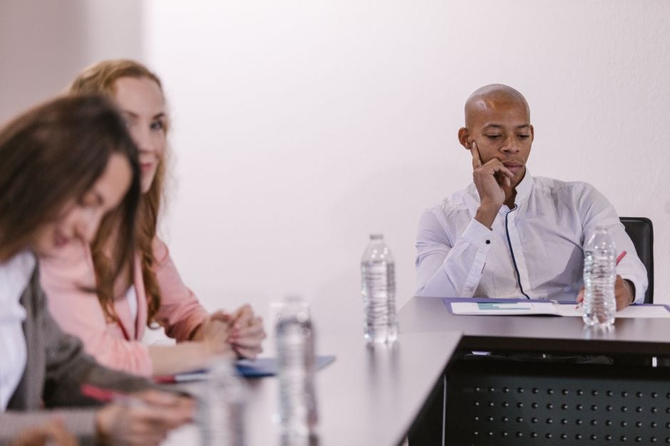 Des professionnels d'affaires engagés dans une réunion formelle autour d'une table de conférence.