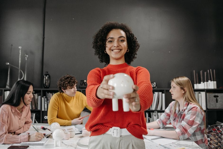 Équipe diverse dans un bureau moderne en train de brainstormer avec des objets créatifs sur la table.