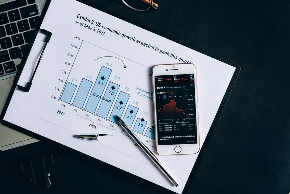 Un smartphone affichant des données boursières repose sur un graphique de rapport financier.